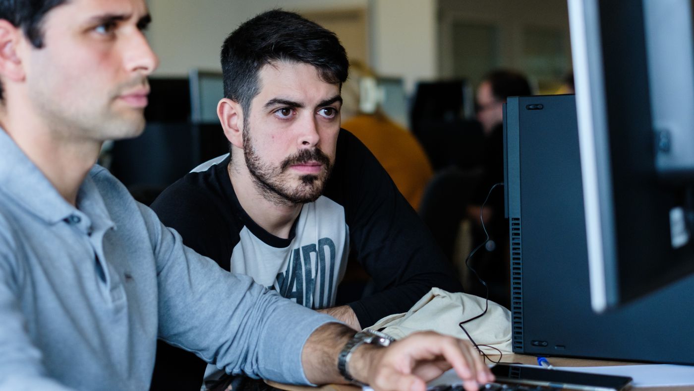 Two people working through a problem together at a screen on the A³ campus